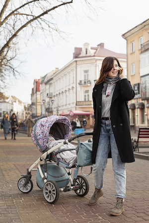 Eine Mutter mit Kinderwagen auf einem Platz in einer Stadt