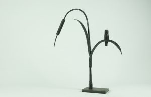 Skulptur av en fågel som sitter på vass från järnsmides-utställningen "Mellan kikaren och städet"