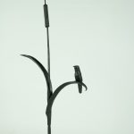Skulptur av en fågel som sitter på vass från järnsmides-utställningen "Mellan kikaren och städet"