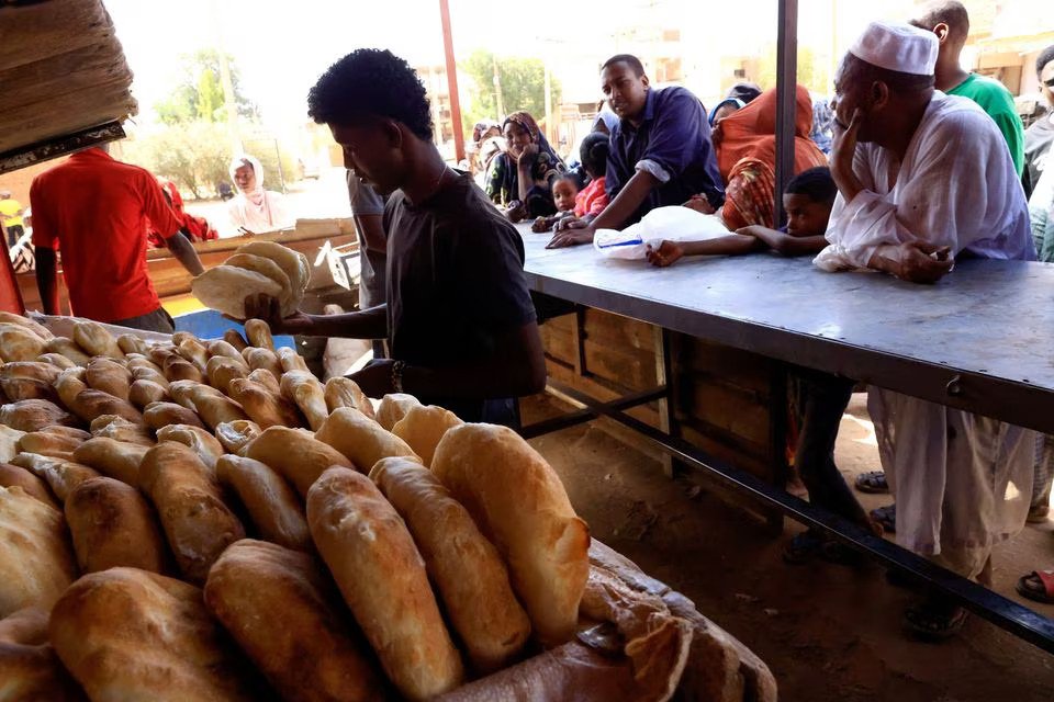 Amidst clashes between the paramilitary Rapid Support Forces and the army in Khartoum North, Sudan, people gather to obtain bread on April 22, 2023, as captured in this image by REUTERS/Mohamed Nureldin Abdallah.