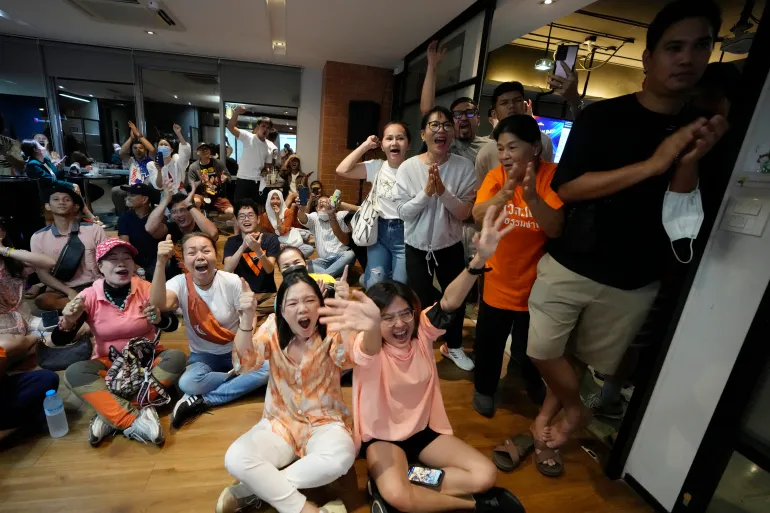 Supporters of Move Forward party cheer as they watch the counting of votes on television at Move Forward Party headquarters in Bangkok, Thailand, Sunday, May 14, 2023
