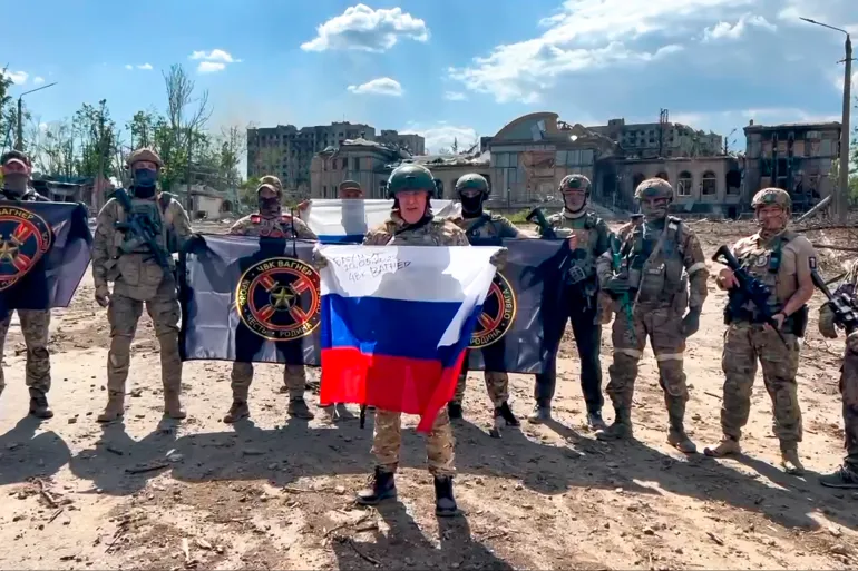Yevgeny Prigozhin, the leader of the Wagner Group, proudly waves the Russian national flag alongside his soldiers in Bakhmut, Ukraine - still from Prigozhin Press Service video.