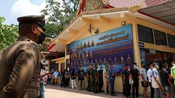 Voters stand in a queue to cast their ballot to vote in the general election at a polling station in Bangkok, Thailand, May 14, 2023.