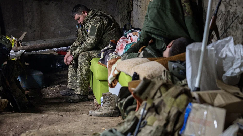 An exhausted Ukrainian serviceman seeks respite in a bomb shelter on the frontlines of Bakhmut, Donetsk region, on April 23, 2023, amidst the ongoing Russian invasion of Ukraine.