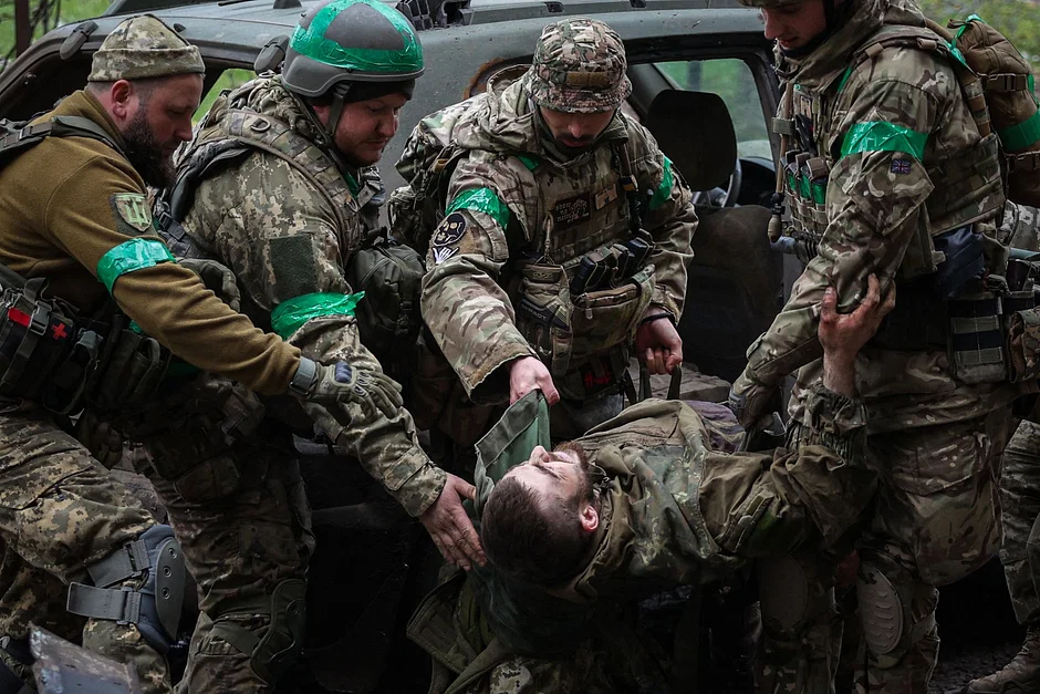 Dedicated Ukrainian servicemen carefully transport a wounded comrade through the streets of Bakhmut, Donetsk region, on April 23, 2023, amidst the tense frontline situation during the Russian invasion of Ukraine.