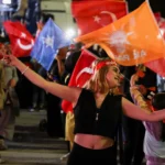 A supporter of Turkish President Tayyip Erdogan waves flags outside the AK Party headquarters, in Ankara, Turkey 15 May, 2023