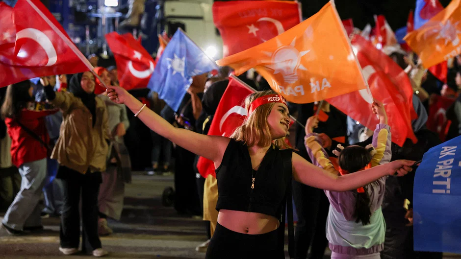 A supporter of Turkish President Tayyip Erdogan waves flags outside the AK Party headquarters, in Ankara, Turkey 15 May, 2023