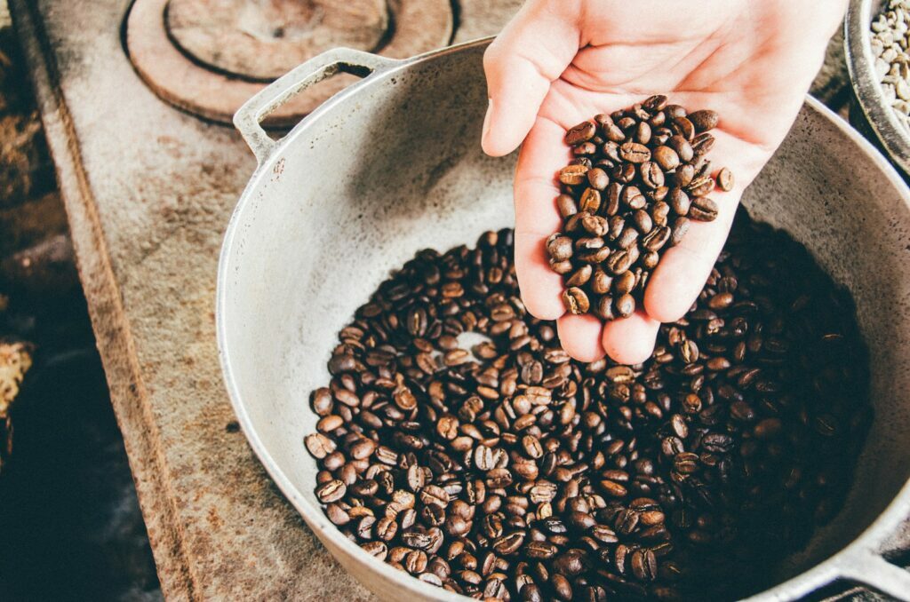 Kaffee-Statistiken: Enthüllung der globalen Auswirkungen. Kaffeebohnen auf einer grauen Stahlwok.