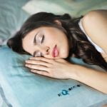 How to Improve Your Sleep Quality Naturally: A Comprehensive Guide woman sleeping on blue throw pillow