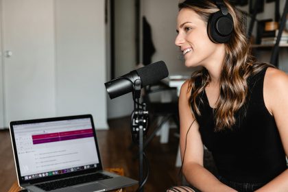 The Top 10 Platforms to Tune In: Navigating the Podcast Universe woman in black tank top sitting on chair in front of microphone