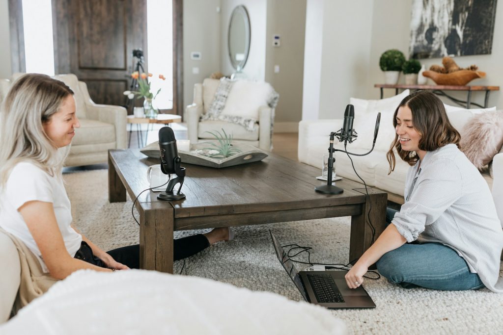 Die Podcast-Welt erkunden: Die Top 10 Plattformen zum Einschalten person in white shirt using black laptop computer on brown wooden table