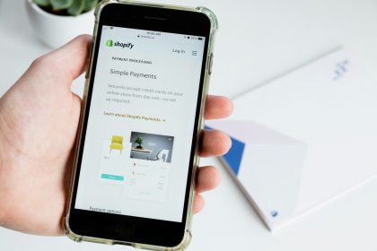 person holding space gray iphone 6 Top 10 Essential Tools for Shopify App Developers: Streamline Your Development Process