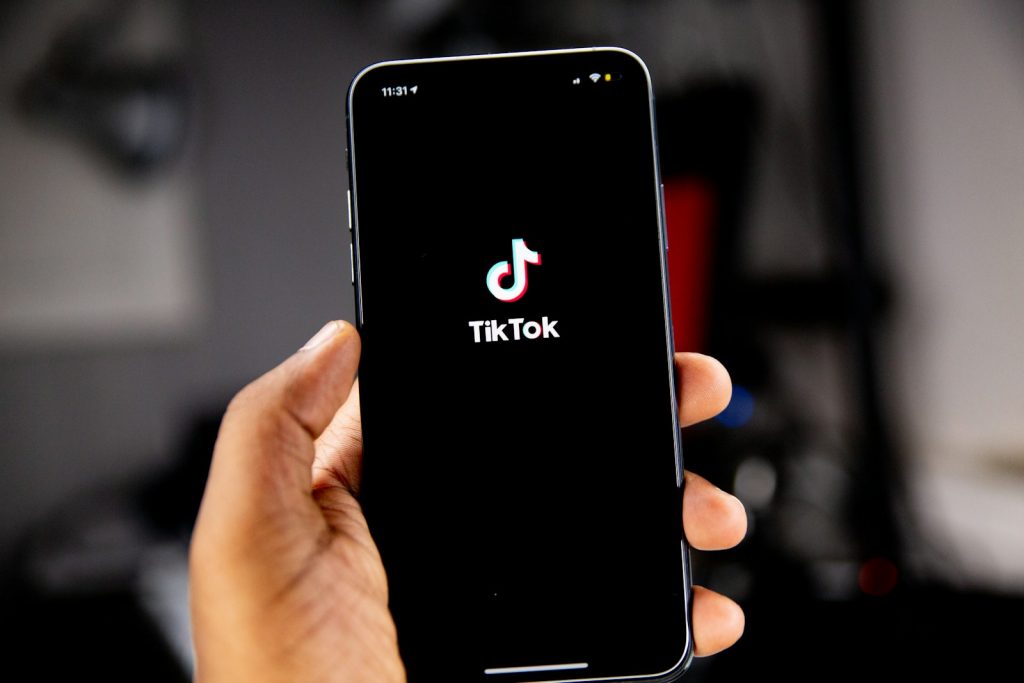 person holding black iphone 5 WooCommerce Merchants First to Integrate with TikTok Shop in the US!