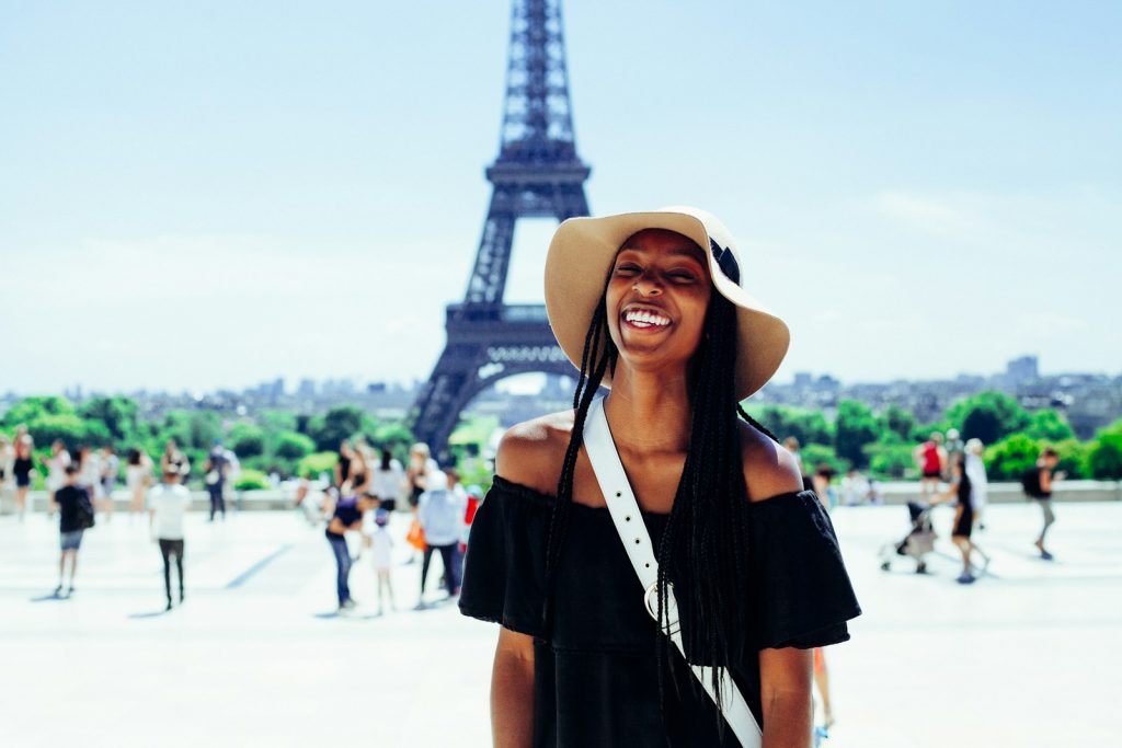 Unveiling the Secrets of Budget Travel: Maximize Your Adventures Without Breaking the Bank woman standing behind Eiffel Tower during daytime