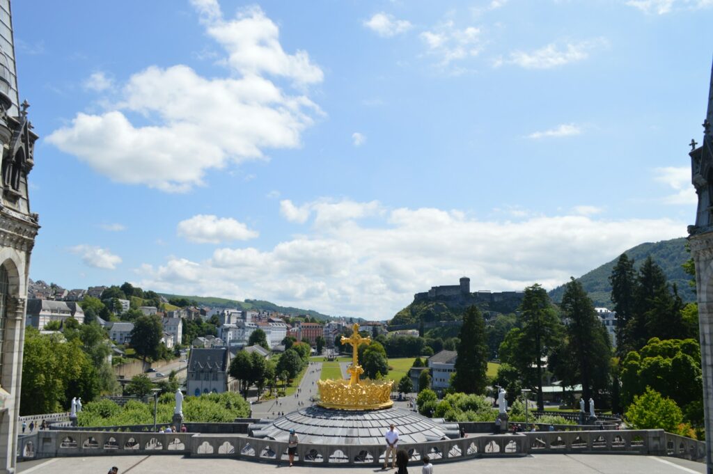 a person standing in front of a fountain Lourdes Religious and Spiritual Pilgrimages