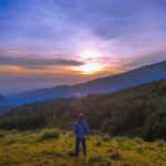 person standing on hill during golden hour