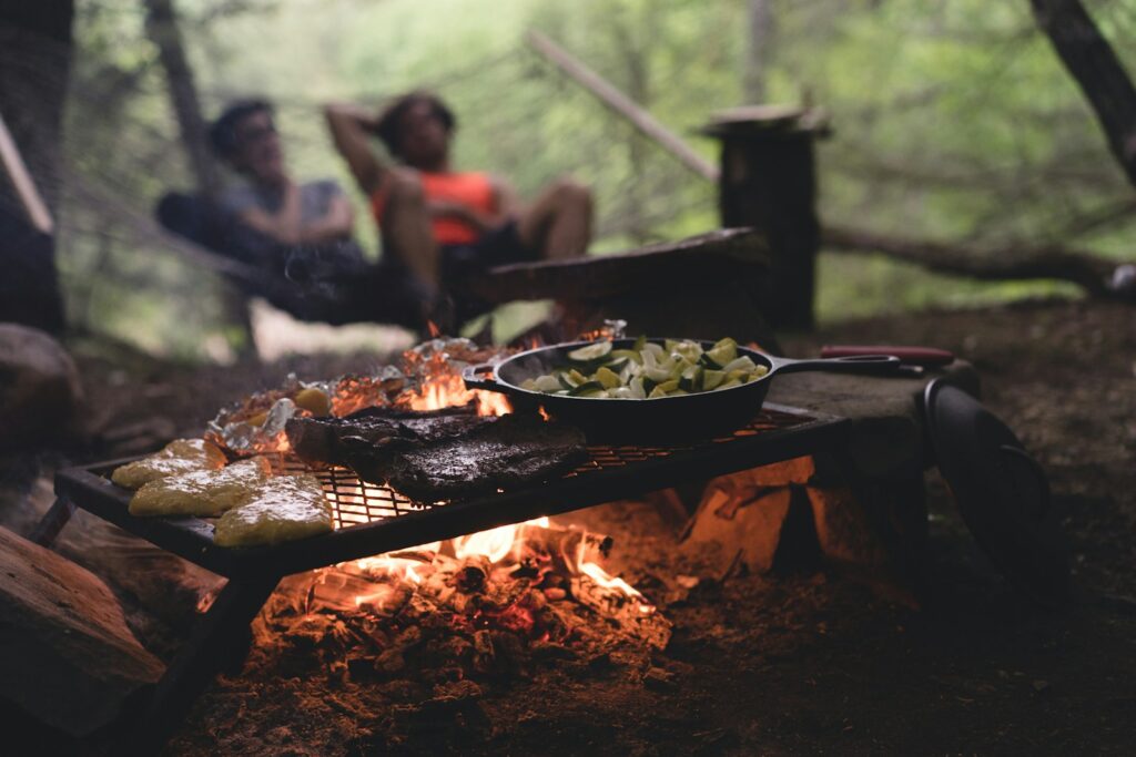 selective focus photo of skillet and meat on top of grill with fire Cooking Classes and Culinary Workshops Bounty of the Earth