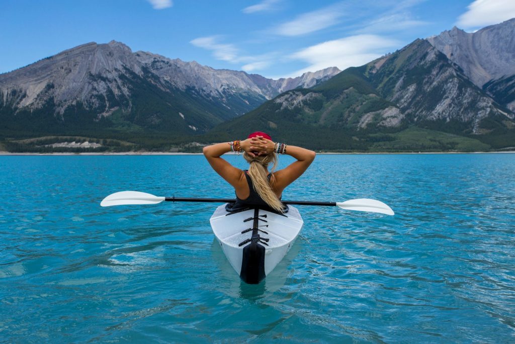 woman riding kayak at the middle of the sea solo travel