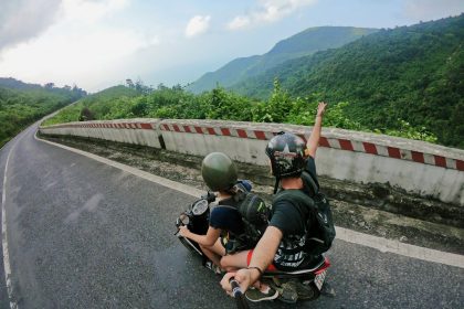 fish eye photography on woman riding motor scooter with man on bridge