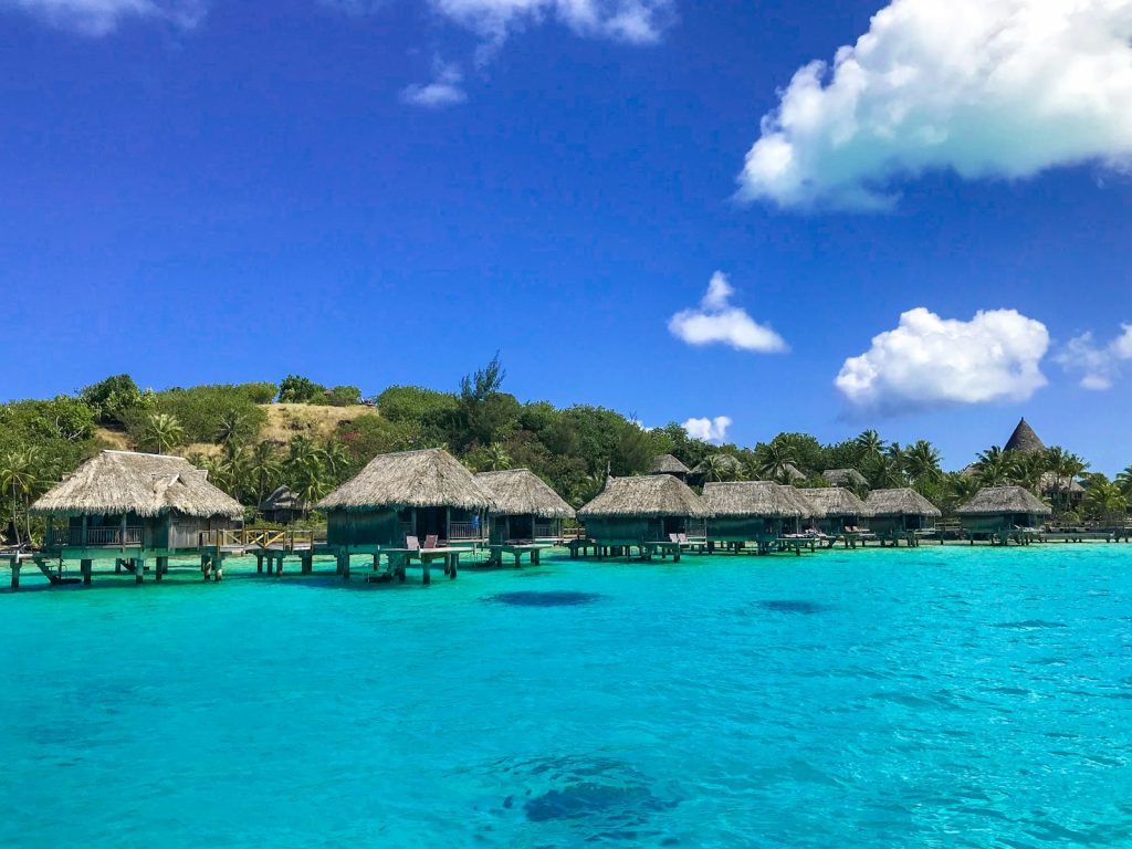 a beach with a bunch of huts in the water Bora Bora Discover Paradise