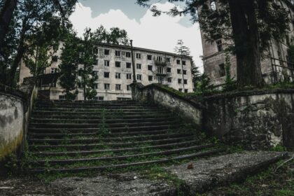 gray concrete building near green trees during daytime