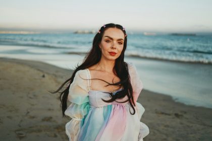 a woman standing on a beach next to the ocean