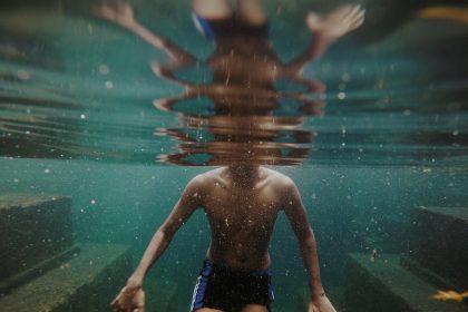 man swimming in body of water