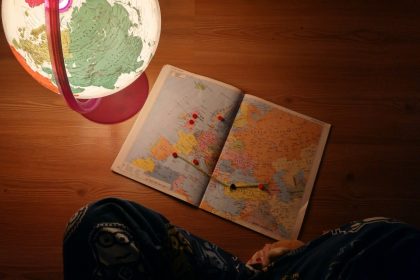 world map near desk globe on brown wooden panel