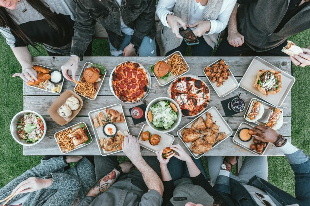 a group of people sitting around a table with food Culinary Adventure Culinary Festivals