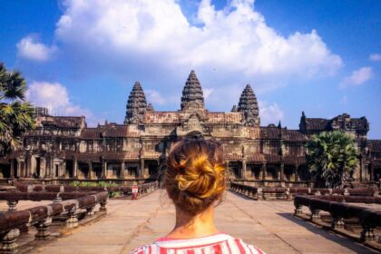 woman wearing red and white striped blouse standing in front of temple