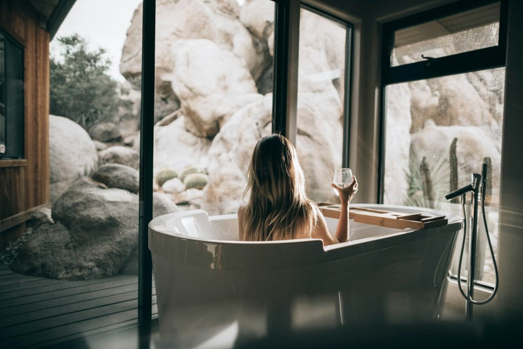woman in white bathtub holding clear drinking glass The Benefits of Spa and Wellness Tourism  The Revitalizing Retreat