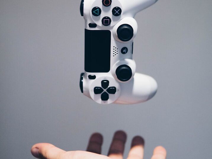 white Sony PS4 DualShock controller over person's palm