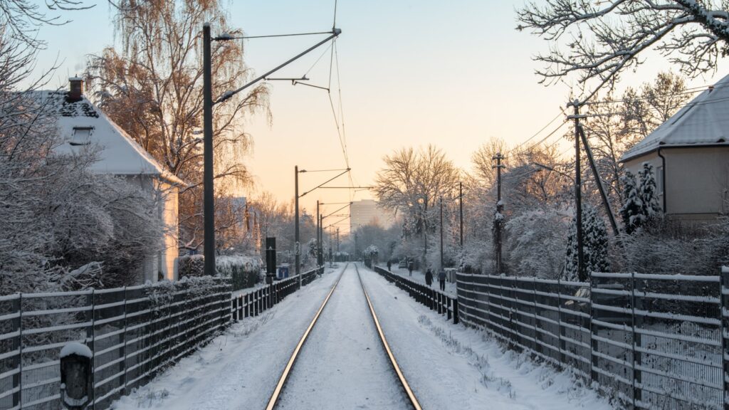 a train track running through a snow covered countryside