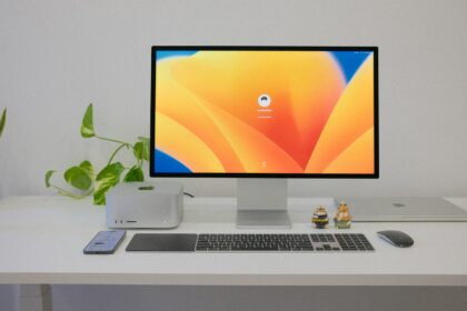 a desktop computer sitting on top of a white desk Apple Studio Display