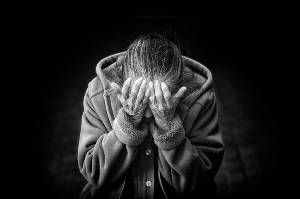 grayscale photography of person covering face Alzheimer