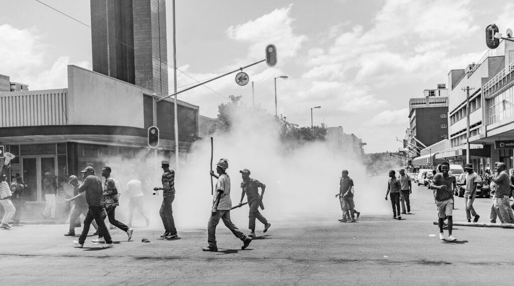 grayscale photo of people on street near buildings during daytime Monthly Riot Points (RP) Stipend LOL Prime