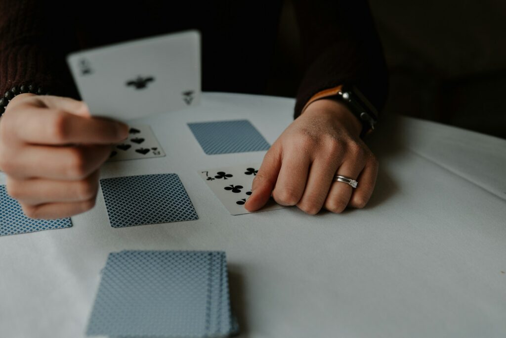 person holding playing cards on white table Playing solo Fireboy and Watergirl 5