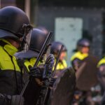 man in uniform holding baton and shield