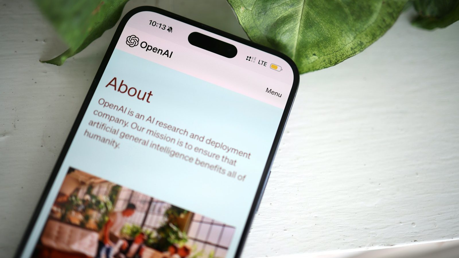 a cell phone sitting on top of a table next to a plant