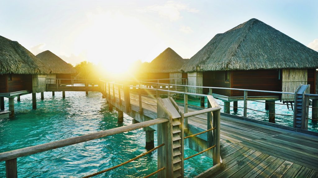 brown wooden dock between houses. 7 Incredible Beach Getaways That Will Blow Your Mind