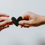 two person holding papercut heart