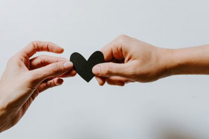 two person holding papercut heart