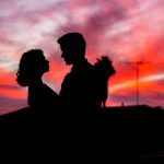 silhouette of man and woman facing each other during golden hour