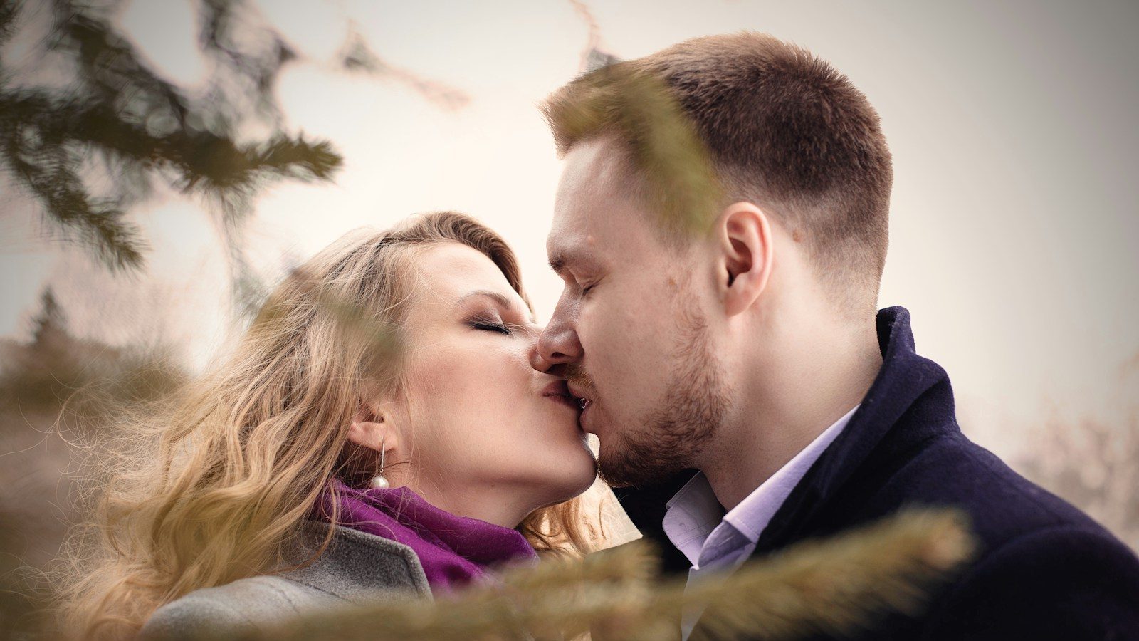 man and woman kissing near green leafed tree. 10 Shocking Red Flags You Should Never Ignore in a Partner