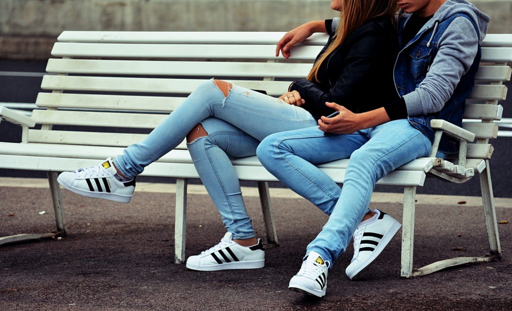 photo of couple sitting on white bench. 10 Shocking Red Flags You Should Never Ignore in a Partner