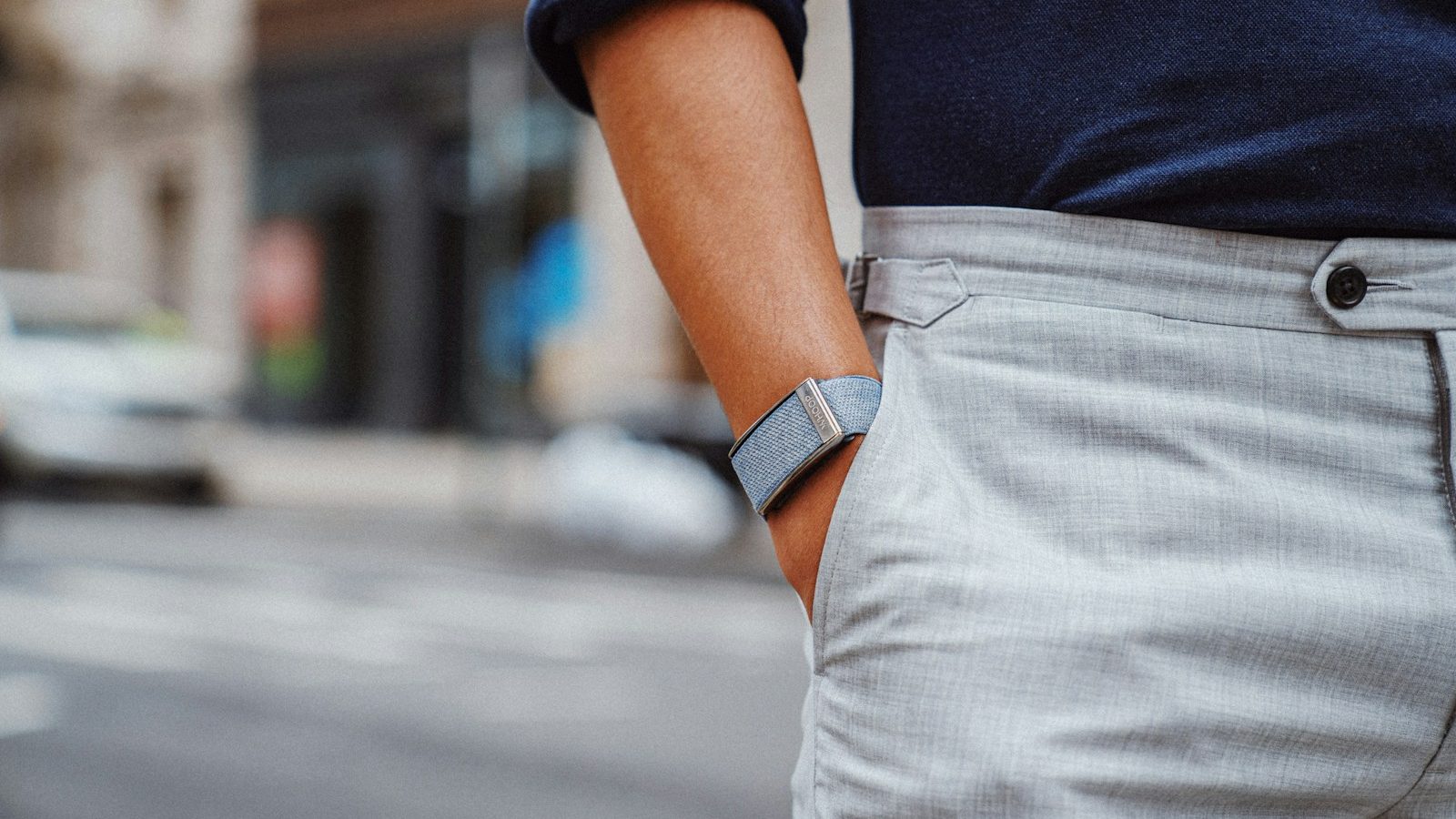 a close up of a person wearing a blue sweater and gray pants