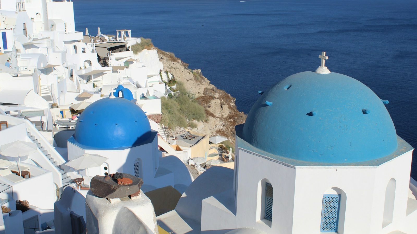 a white building with blue domes by the water