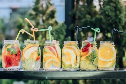 six clear glass mason jars filled with juice on black table