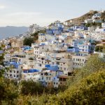 a very tall hill covered in lots of blue and white buildings