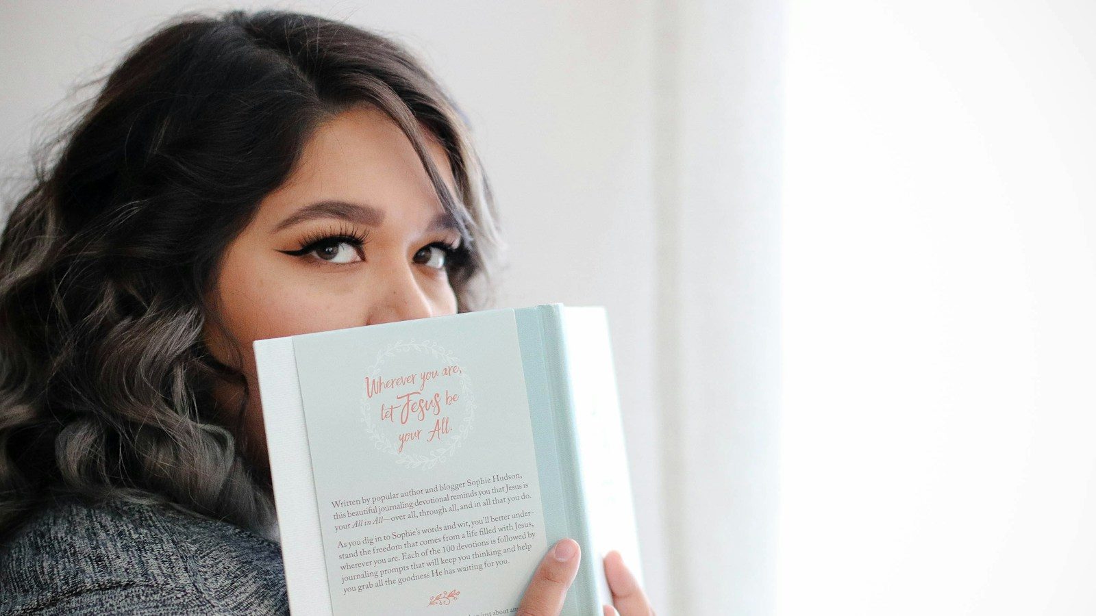 woman covering her face with book